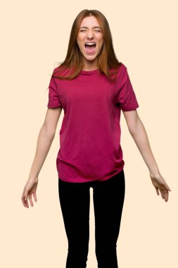 İzole sarı arka plan açık ağız ile ön bağırarak genç Kızıl saçlı kız