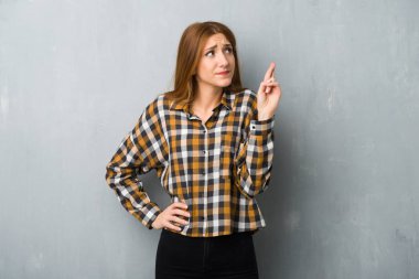 Grunge Duvar ile en iyi dilek ve geçiş parmakları genç Kızıl saçlı kız