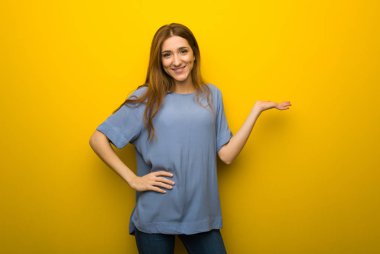 Bir reklam eklemek için sarı duvar arka plan boşaltmak hayali avuç içinde tutan genç Kızıl saçlı kız