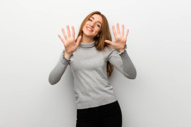 Kızıl saçlı kız beyaz duvar on parmak ile sayma üzerinde