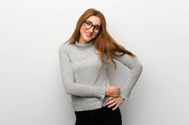 Kızıl saçlı kız gözlüklü ve mutlu beyaz duvar üzerinde