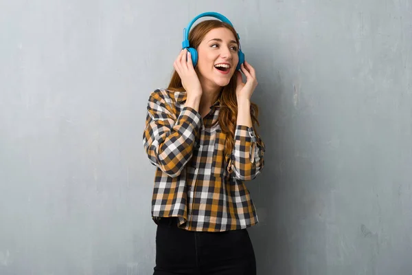 Chica Pelirroja Joven Sobre Pared Grunge Escuchando Música Con Auriculares —  Fotos de Stock