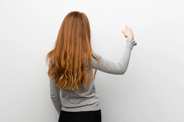 Pelirroja Sobre Pared Blanca Apuntando Hacia Atrás Con Dedo Índice — Foto de Stock