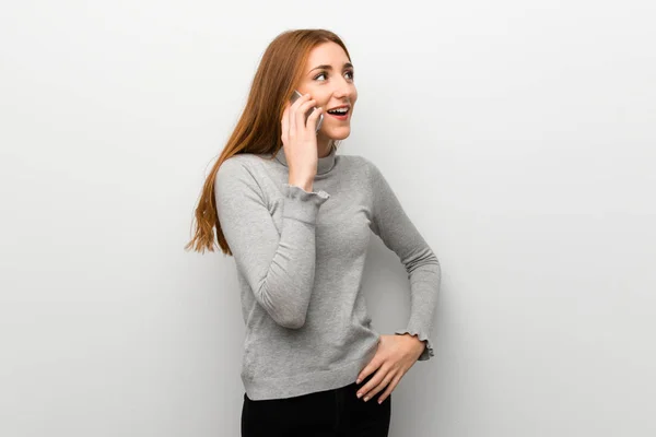 Redhead Κορίτσι Λευκό Τοίχο Κρατώντας Μια Συνομιλία Κινητό Τηλέφωνο — Φωτογραφία Αρχείου