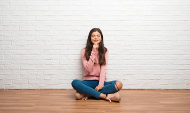 Çene üzerinde el ile bakıyordu bir odada katta oturan genç kız