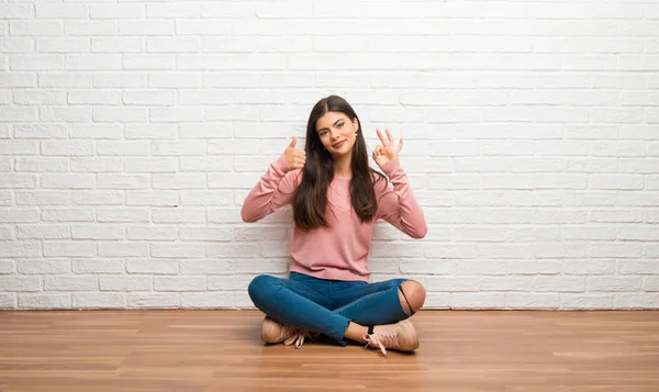 Девочка Подросток Сидящая Полу Комнате Показывая Знак Показывая Большой Палец — стоковое фото