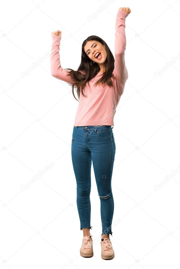 A full-length shot of a Teenager girl with pink shirt celebrating a victory in winner position