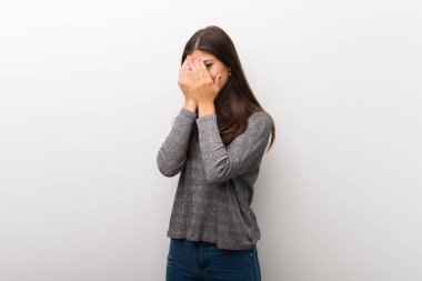 Gözleri eller tarafından kapsayan ve parmaklarının arasından seyir izole beyaz backgorund genç kız