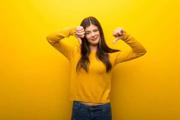 Tiener Meisje Levendige Gele Achtergrond Weergegeven Duim Omlaag Met Beide — Stockfoto