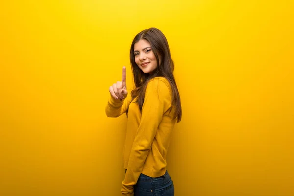 Menina Adolescente Fundo Amarelo Vibrante Mostrando Levantando Dedo — Fotografia de Stock