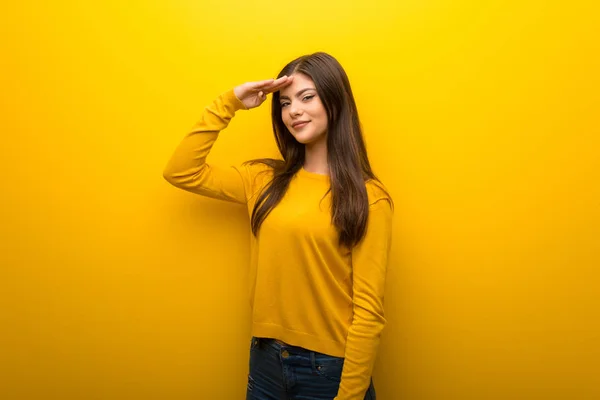 Teenager Girl Vibrant Yellow Background Saluting Hand — Stock Photo, Image