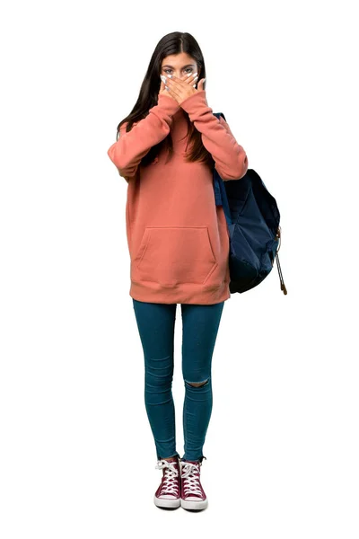一个少年女孩的全长照片 她拿着运动衫和背包 用手捂住嘴 因为她说了一些不恰当的话 — 图库照片