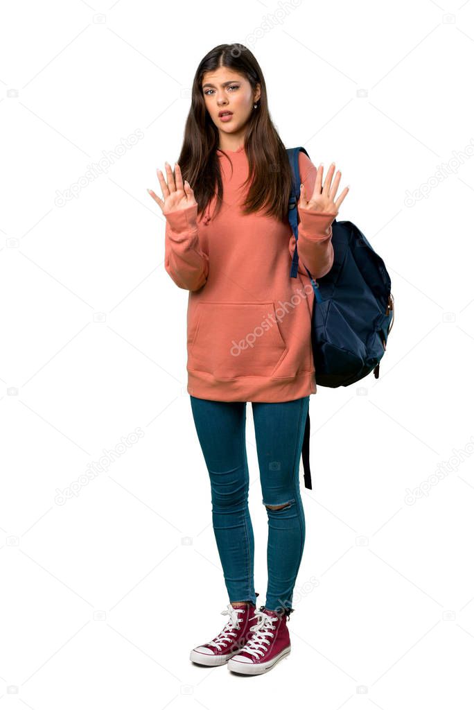 A full-length shot of a Teenager girl with sweatshirt and backpack making stop gesture with both hands