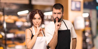 Aşçılar bir işaret parmağını ağzına koyarak sessizlik jest gösteren birkaç