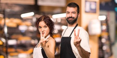 Çift aşçıların mutlu ve sayım iki parmak ile