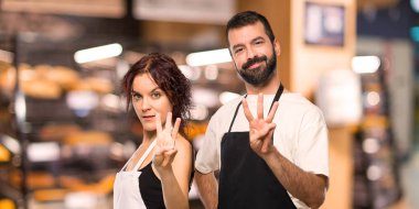 Çift aşçıların mutlu ve sayım üç parmaklı