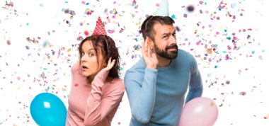 Balonlar ve bir şey kulak konfeti bir parti ile el koyarak dinleme Doğum günü şapka ile çift