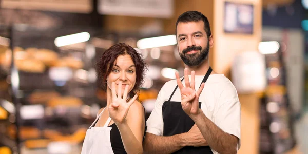 Couple of cooks happy and counting four with fingers