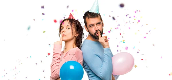 Casal Com Balões Chapéus Aniversário Mostrando Sinal Fechar Boca Gesto — Fotografia de Stock