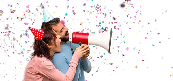 Casal Com Chapéus Aniversário Segurando Megafone Com Confete Uma Festa — Fotografia de Stock