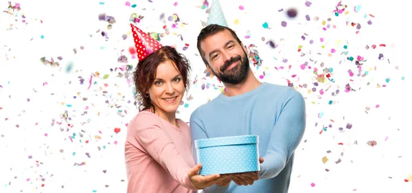 Casal Com Chapéus Aniversário Segurando Presente Com Confete Uma Festa — Fotografia de Stock