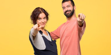 Hamile kadın ile çift parmak seni işaret izole sarı zemin üzerine kendine güvenen bir ifade ile