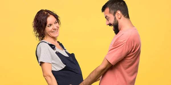 Gelukkige Paar Met Zwangere Vrouw Zoenen Geïsoleerde Gele Achtergrond — Stockfoto