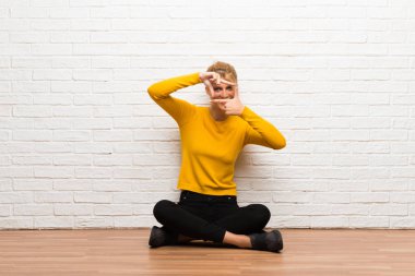 Yüz odaklanarak katta oturan genç kız. Çerçeve sembolü