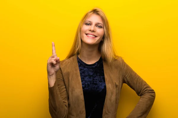 Блондинка Яскравому Жовтому Фоні Показує Піднімає Палець Знак Кращих — стокове фото