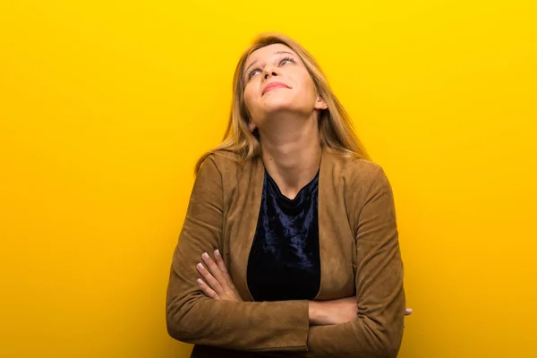 Ragazza Bionda Uno Sfondo Giallo Vibrante Che Dubbi Gesto Mentre — Foto Stock