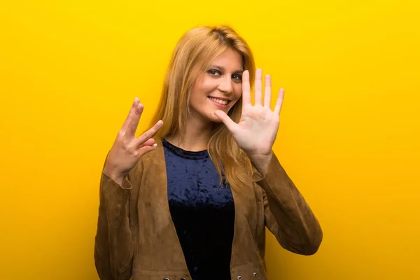 Блондинка Яскравому Жовтому Тлі Підраховує Вісім Пальцями — стокове фото