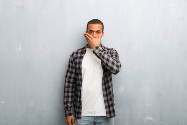 Uygunsuz bir şey söylediğin için el ile ağız kapsayan kareli gömlek ile genç Afro-Amerikan adam