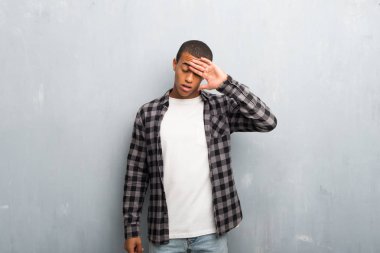 Yorgun ve hasta ifade ile damalı gömlek ile genç Afro-Amerikan adam