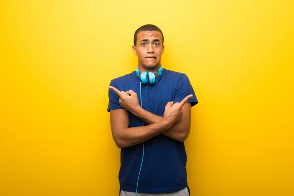 疑問を持つ根を指している黄色の背景の青い シャツとアフリカ系アメリカ人 — ストック写真
