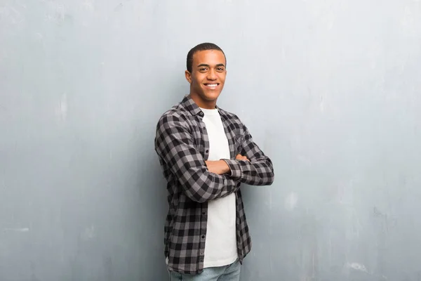 年轻的非洲裔美国男子格子衬衫保持手臂交叉的侧向位置 而微笑 — 图库照片