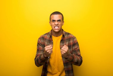 Canlı sarı arka planda tarafından kötü bir durum hayal kırıklığına uğramış genç Afro-Amerikan adam