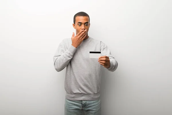 African American Człowieka Tle Białej Ściany Trzymając Kartę Kredytową Zaskoczony — Zdjęcie stockowe