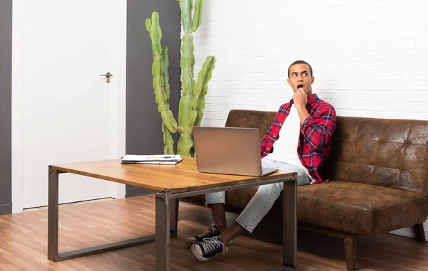 African American Man Met Laptop Woonkamer Twijfels Terwijl Opzoeken — Stockfoto