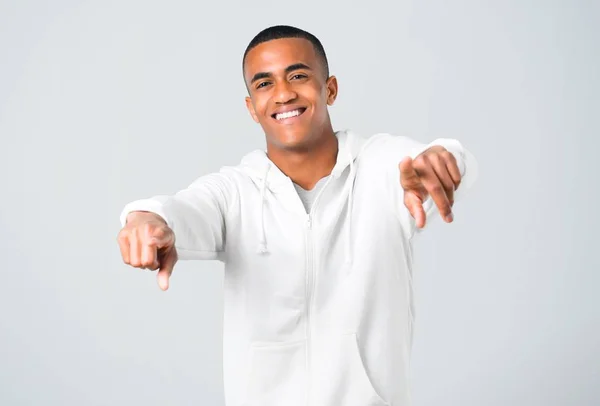 笑顔灰色の背景の中に白いトレーナー ポイント指で若い男の浅黒い肌 — ストック写真