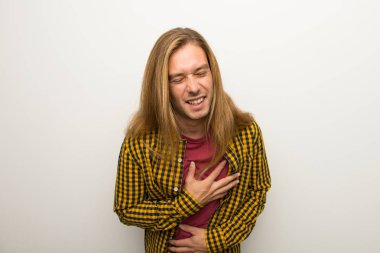 Sarışın adam uzun saçlı ve göğsüne el koyarken çok kareli gömlek gülümseyen