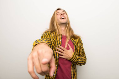 Sarışın adam uzun saçlı ve biri parmak ile işaret ve çok gülüyor kareli gömlek ile