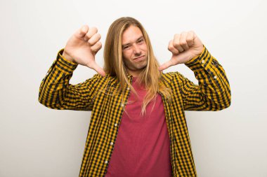 Sarışın adam uzun saçlı ve kareli gömlek başparmak aşağı her iki el ile gösterilen
