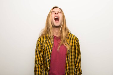 Sarışın adam uzun saçlı ve geniş açık ağız ile ön bağırarak kareli gömlek ile