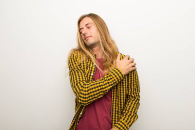 Sarışın adam uzun saçlı ve kareli gömlek için bir çaba yapılmış olan omuz ağrısı acı ile