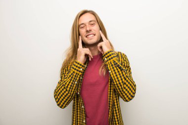 Sarışın adam uzun saçlı ve mutlu ve keyifli bir ifadeyle gülümseyen kareli gömlek ile