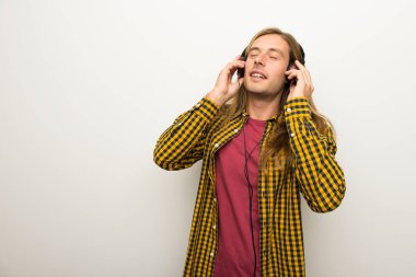 Sarışın adam uzun saçlı ve kareli gömlek kulaklık ile müzik dinlemek