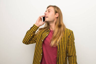 Sarışın adam uzun saçlı ve kareli gömlek cep telefonu ile bir konuşma tutmak ile