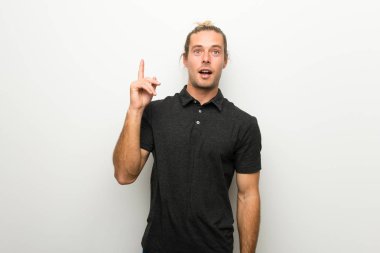 Beyaz duvar parmak işaret bir fikir düşünce üzerinde uzun saçlı sarışın adam