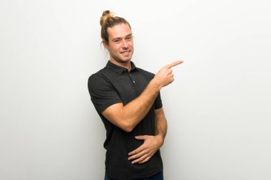 Beyaz duvar işaret parmağı lateral pozisyonda Side'ye üzerinde uzun saçlı sarışın adam