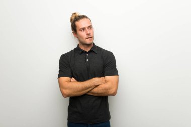 Beyaz duvar ile karıştırmayın yüz ifadesi sırasında ısırıkları dudak üzerinde uzun saçlı sarışın adam